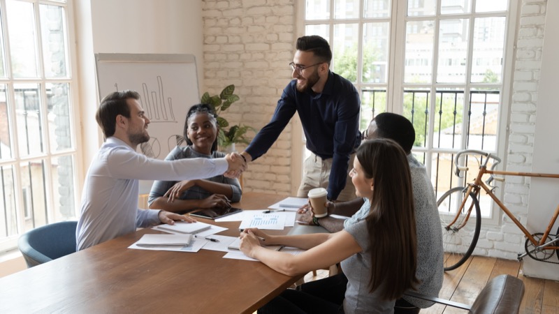 Two sales and marketing professionals shaking hands after a successful meeting